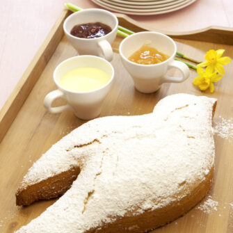 Colomba di torta Paradiso spolverata su ripiano di legno