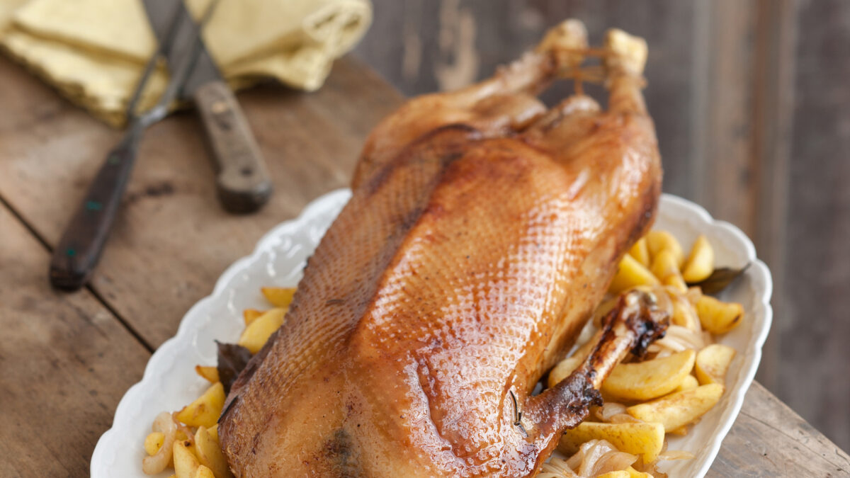 Oca al forno con patate e cipolle fritte