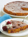 Fetta di torta di carote con ciliegie e panna su piatto