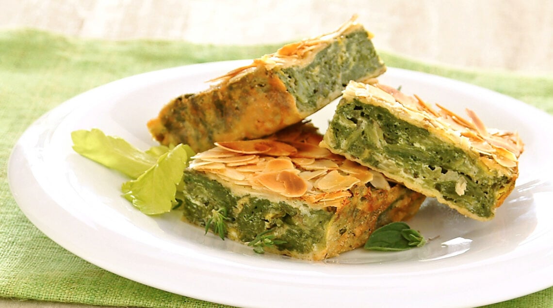 fette torta verde con mandorle croccanti su piatto