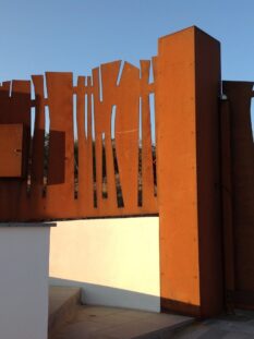 Tenuta di Castellaro, recinzione di ispirazione africana in acciaio cor-ten, di Luigi Radici