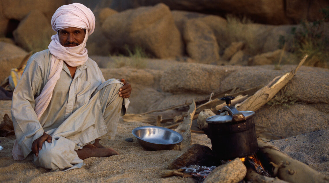 Algeria, La maggior parte della popolazione algerina è composta da una base etnica berbera. In questa foto, un uomo sta cucinando in un campo