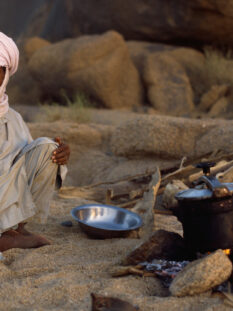 Algeria, La maggior parte della popolazione algerina è composta da una base etnica berbera. In questa foto, un uomo sta cucinando in un campo