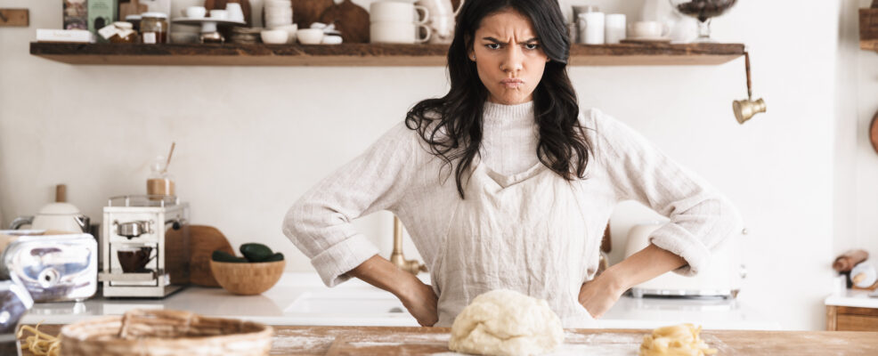Portrait of angry european woman making homemade pasta of dough