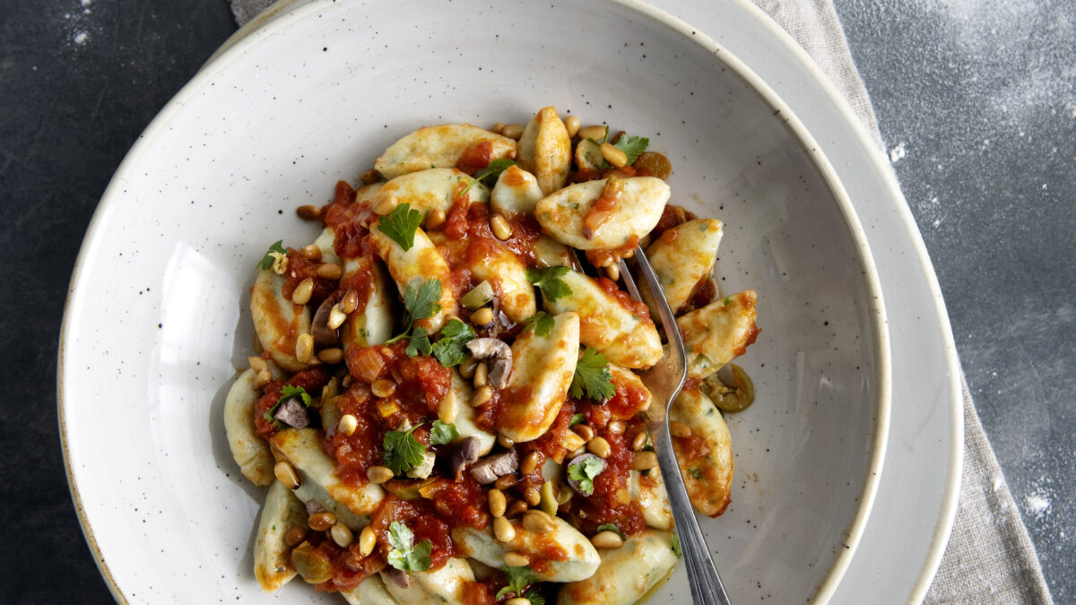 Gnocchi al sapore di baccalà con olive e pinoli