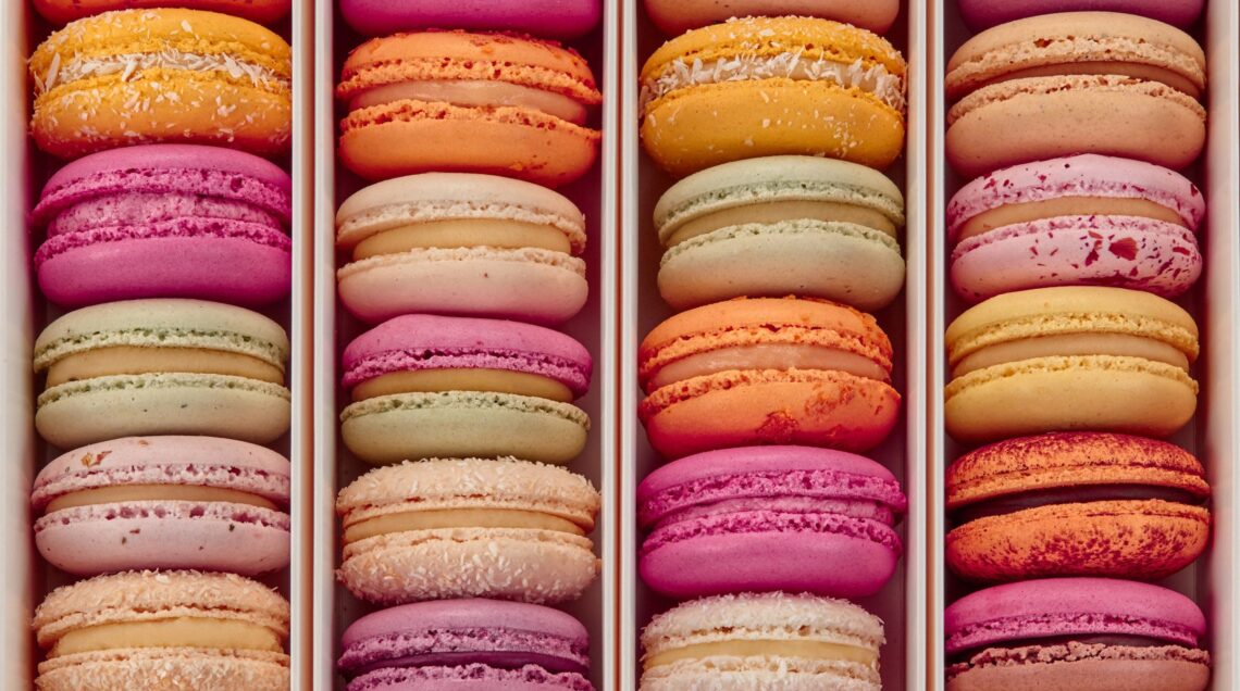Top view of colorful macarons in rows in box