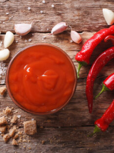 Red chilli sauce Sriracha / ingredients on the table.