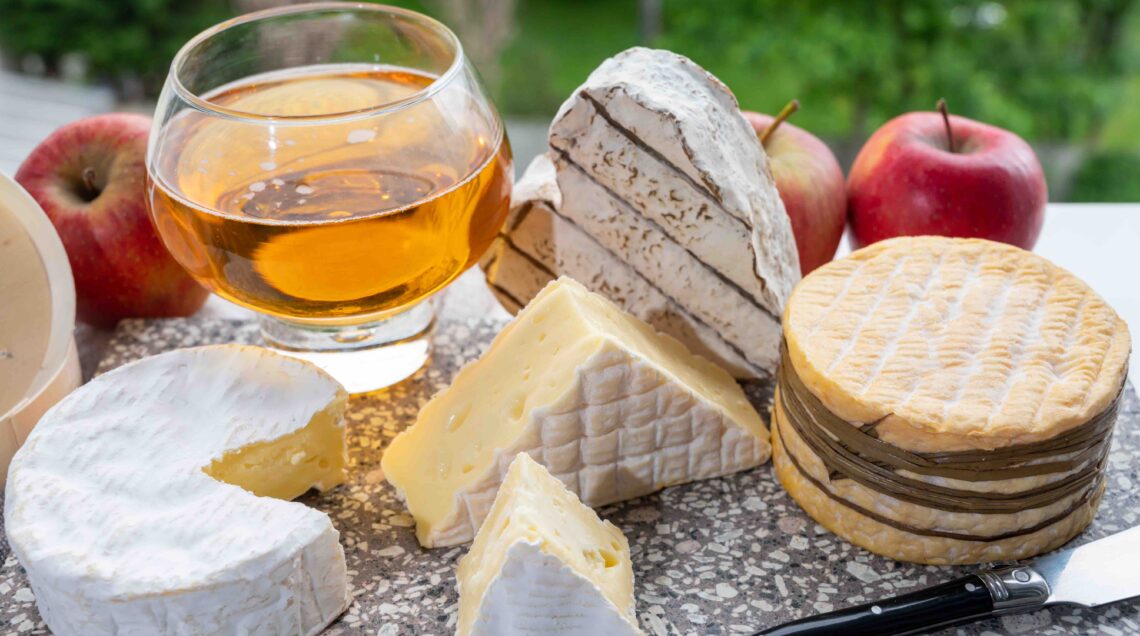 Cow cheeses of Normandy region and glass of apple cider