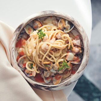 Spaghetti alle vongole veraci, calamaretti spillo, tartare di pesce e coulis di caponata