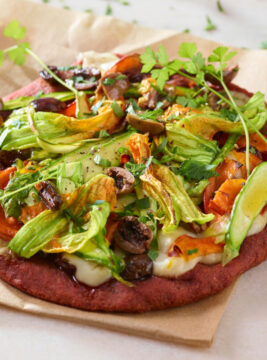 Pizza alla barbabietola con fiori di zucca e asparagi