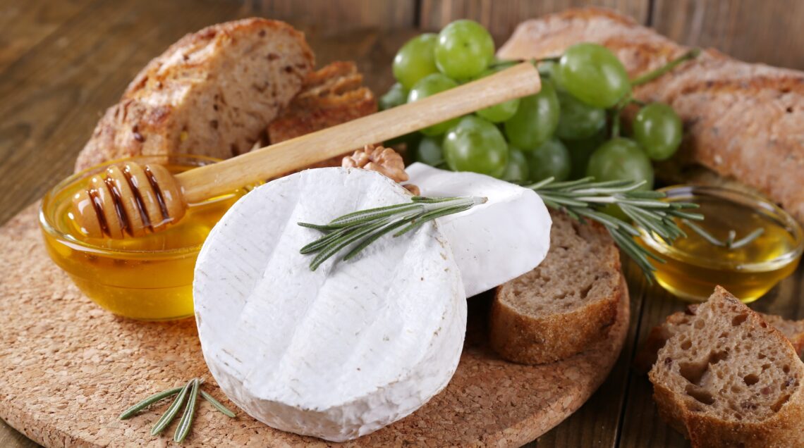 Camembert cheese, bread, honey and grapes