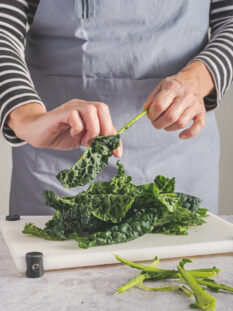 mani che puliscono cavolo nero