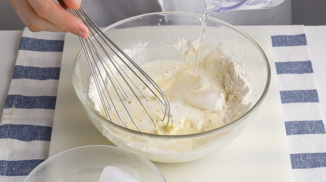 ciotola con gli ingredienti di una pastella mescolati da una frust