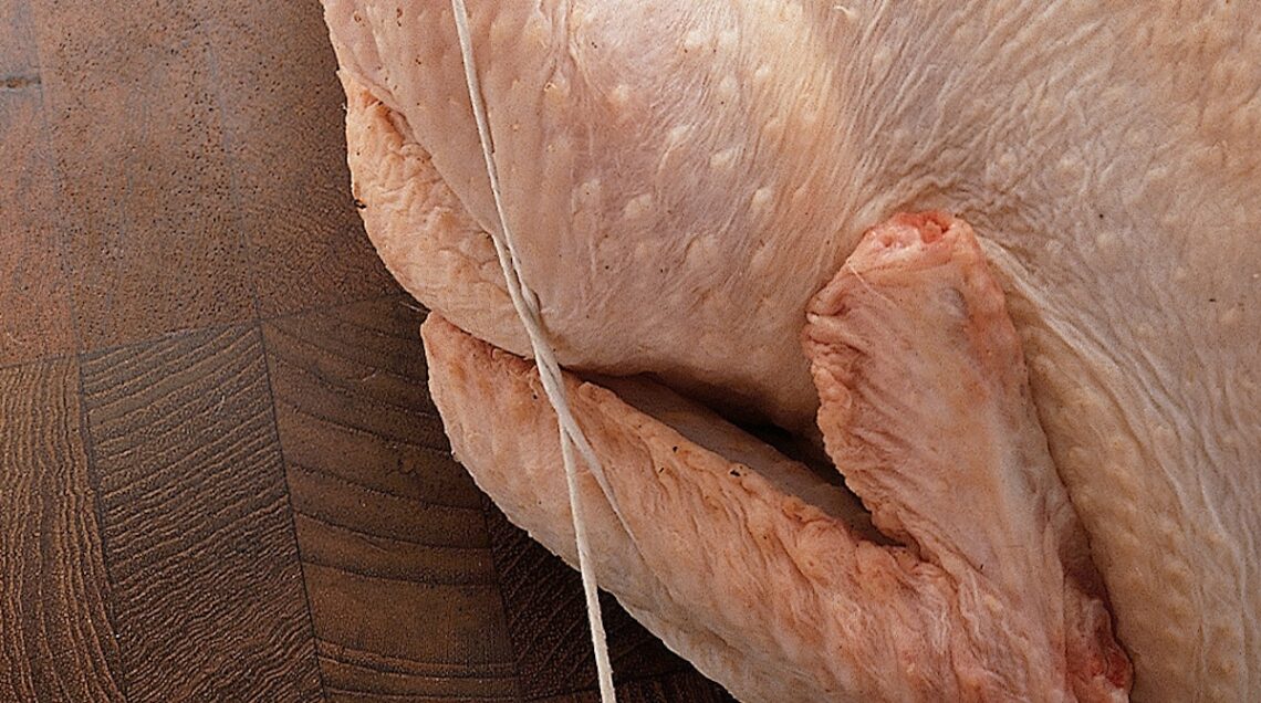pollo crudo con ala e coscia legate dallo spago