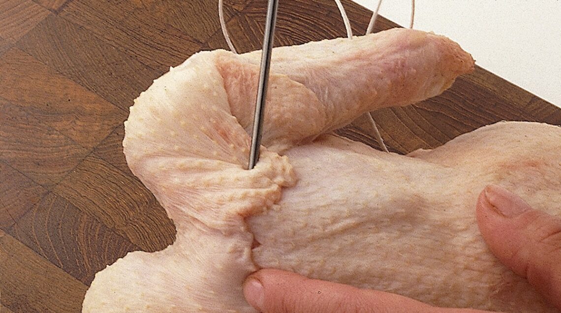 pollo crudo con pelle del collo ripiegata e cucita sulla carcassa