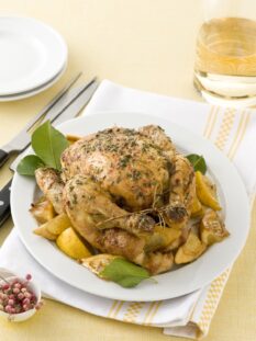 pollo arrosto alle erbe circondato da spicchi di limone