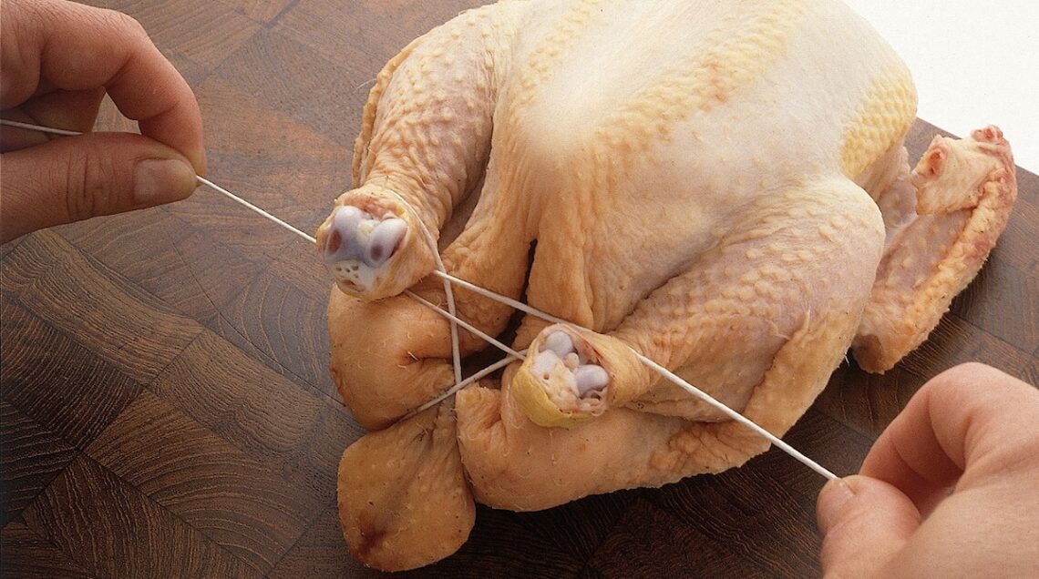 pollo crudo con le cosce legate da un giro di spago
