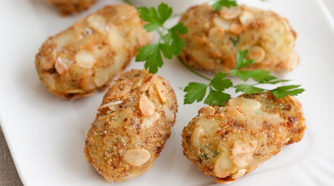 polpettine di patate fritte di forma allungata con scaglie di mandorle