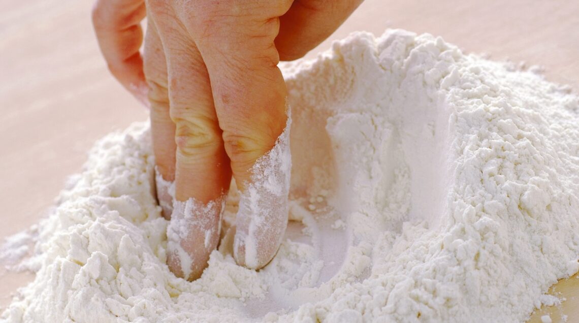 dita che formano un incavo nella farina per la pasta fresca