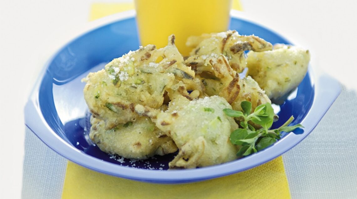 frittelle salate con verdure su piatto celeste e bicchiere di birra