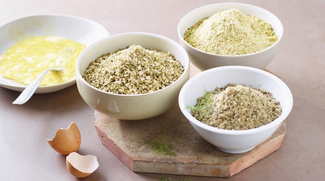 ciotole con diverse panure, guscio d'uovo e uovo sbattuto