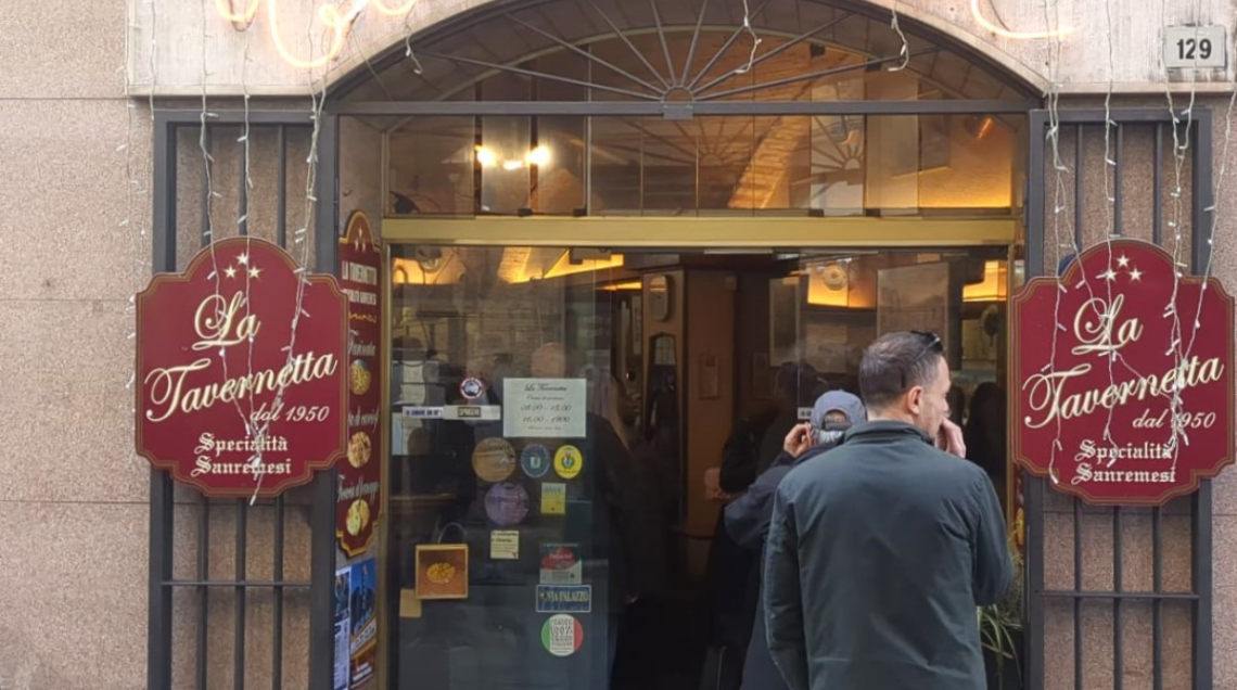 Facciata esterna del locale "La Tavernetta" a Sanremo, con insegna tradizionale e menu esposto