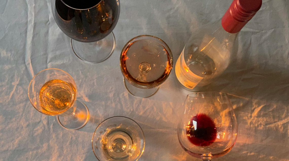 Bicchieri e bottiglie di vini differenti