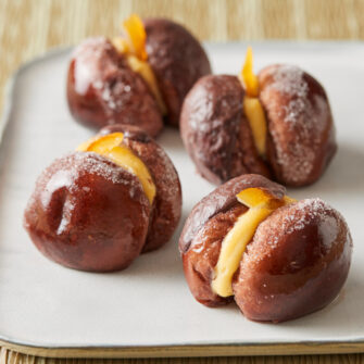 dolcetti al cioccolato, le pesche di prato sono farcite con crema e glassate