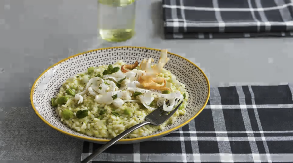 Piatto con risotto verde alle fave, seppie foglie di menta