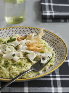 Piatto con risotto verde alle fave, seppie foglie di menta
