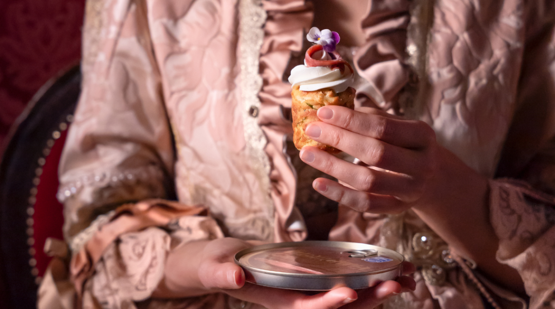 una mano con una veste teatrale regge un finger all'acciuga