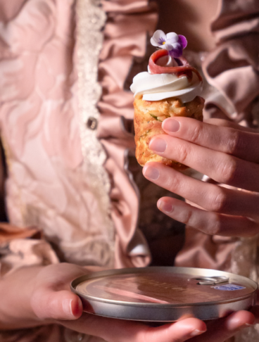 una mano con una veste teatrale regge un finger all'acciuga