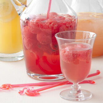caraffa e bicchiere con cocktail rosso all'anguria