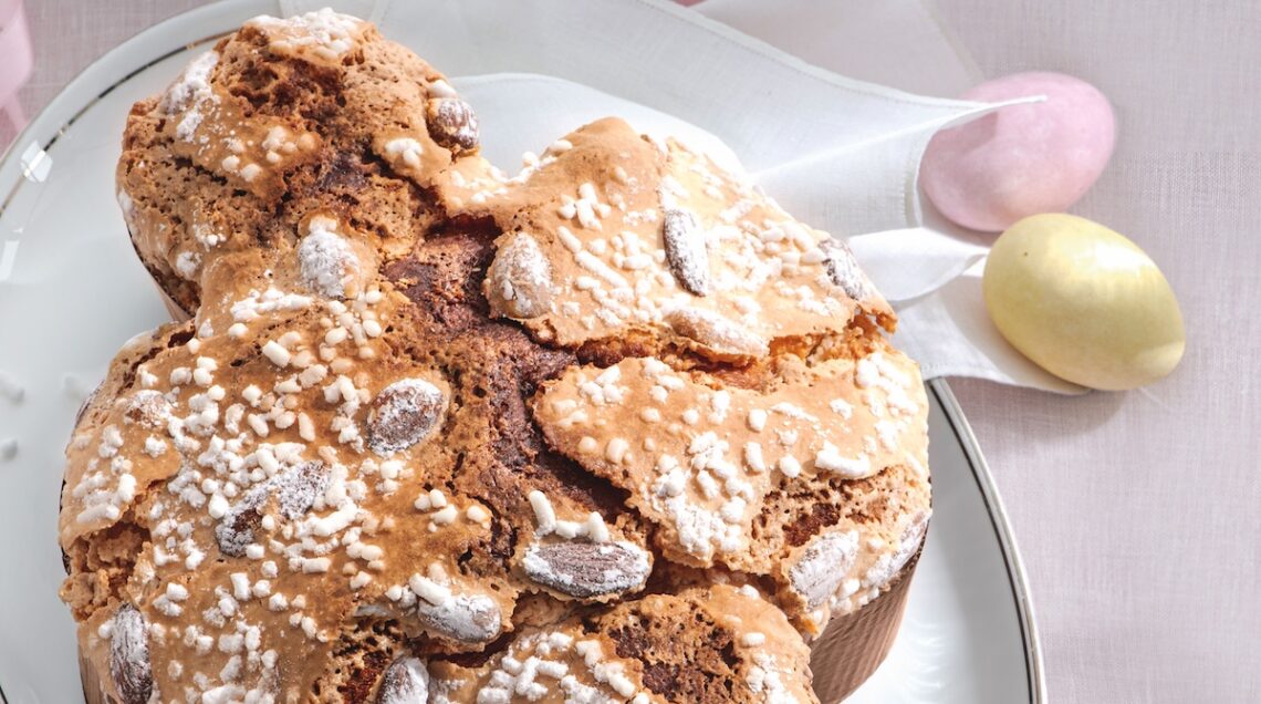colomba pasquale su piatto bianco con ovetti di zucchero a fianco