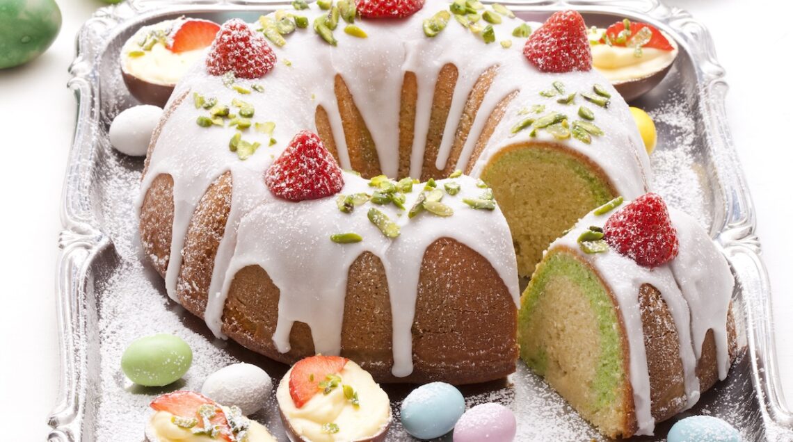 Ciambella con glassa bianca guarnita con fragole e ovetti di cioccolato