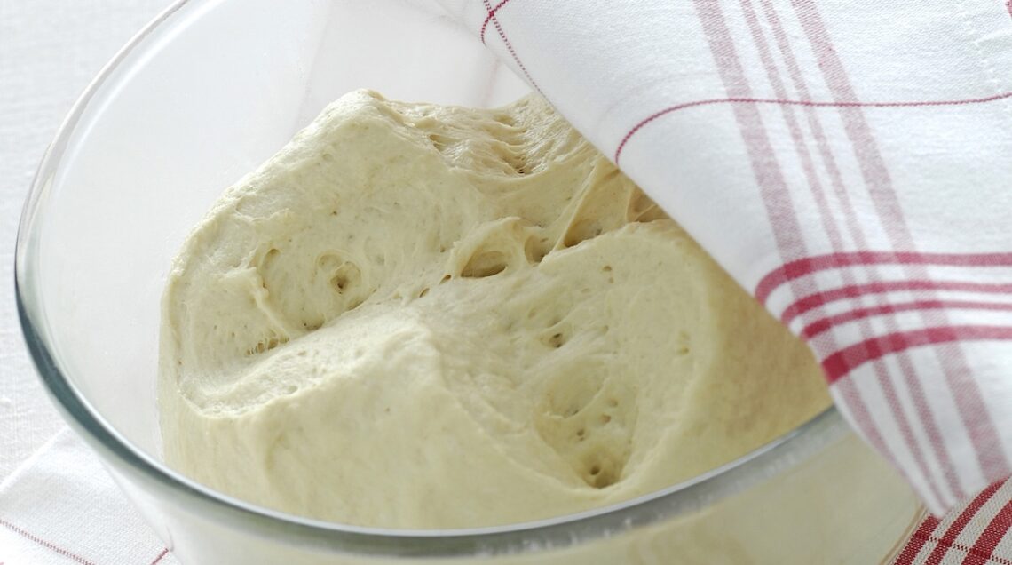 impasto in lievitazione in una ciotola semicoperto da un telo