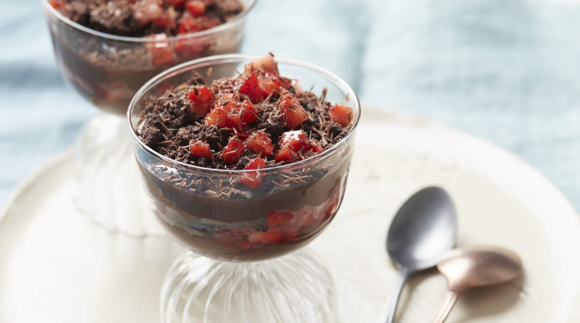 Dolce al bicchiere con crema al cioccolato e fragole su piatto