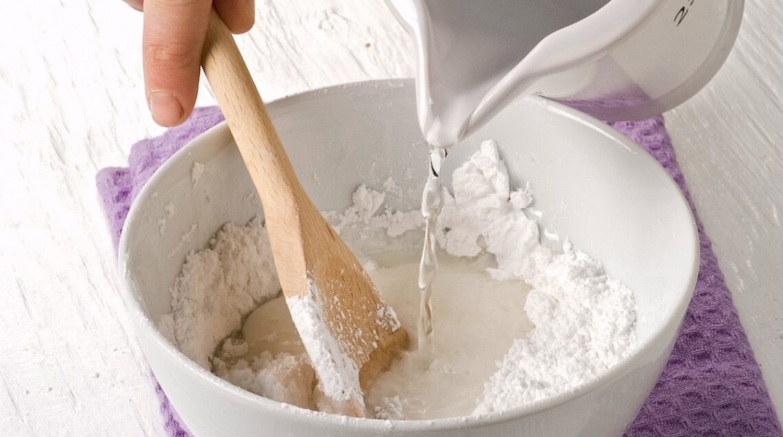 acqua versata in una ciotola contenente zucchero a velo