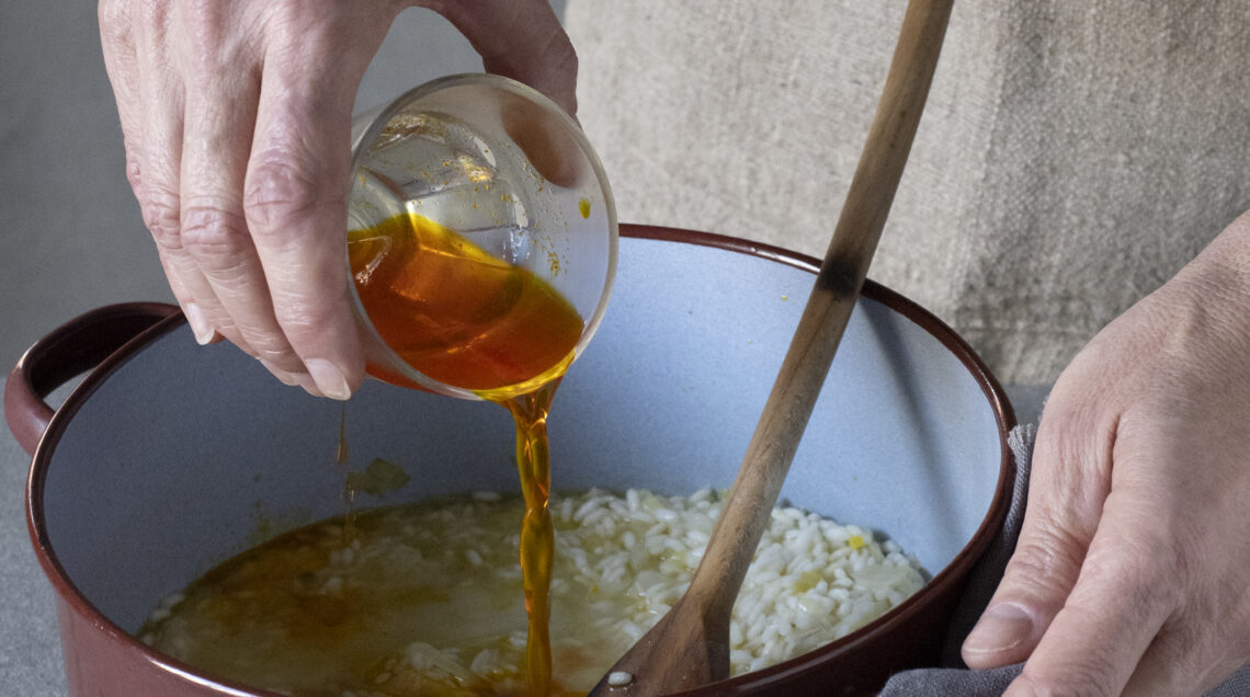mani che versano salsa su risotto