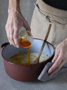 mani che versano salsa su risotto