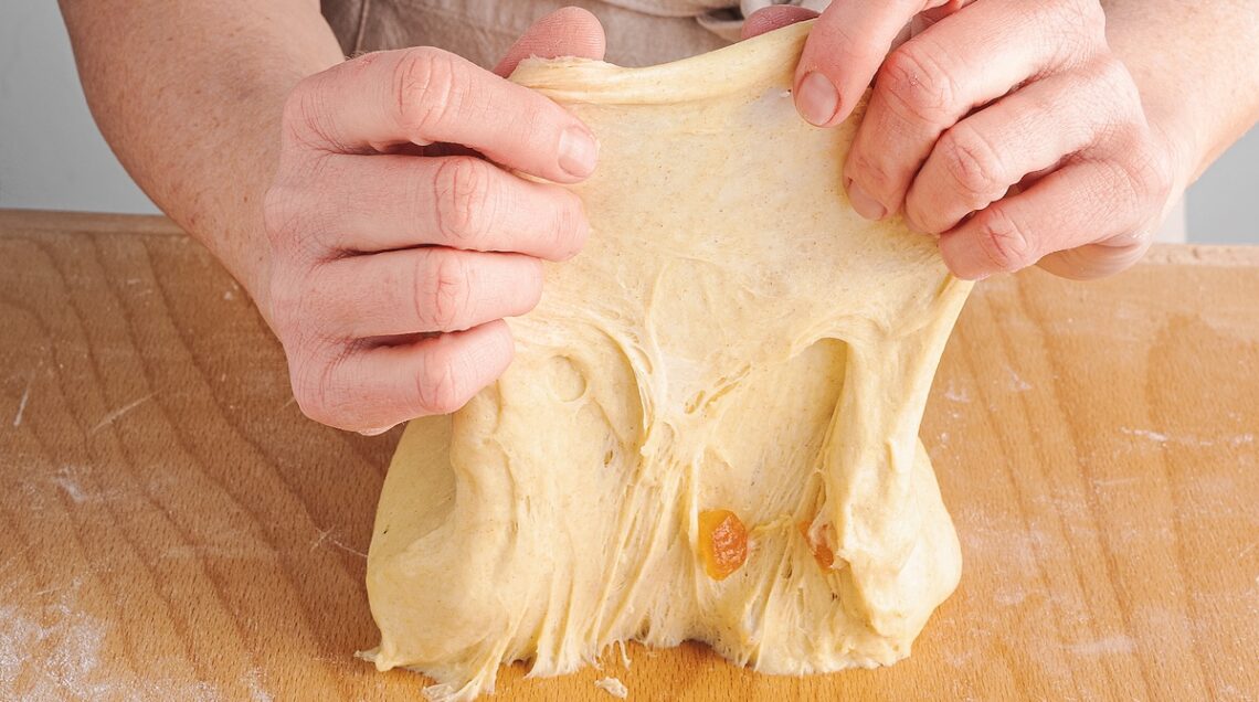 lavorazione dell'impasto a mano sul piano di legno