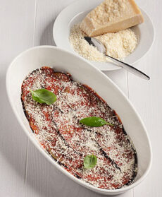 Terrina di parmigiana di melanzane con spolverata di parmigiano grattuggiato