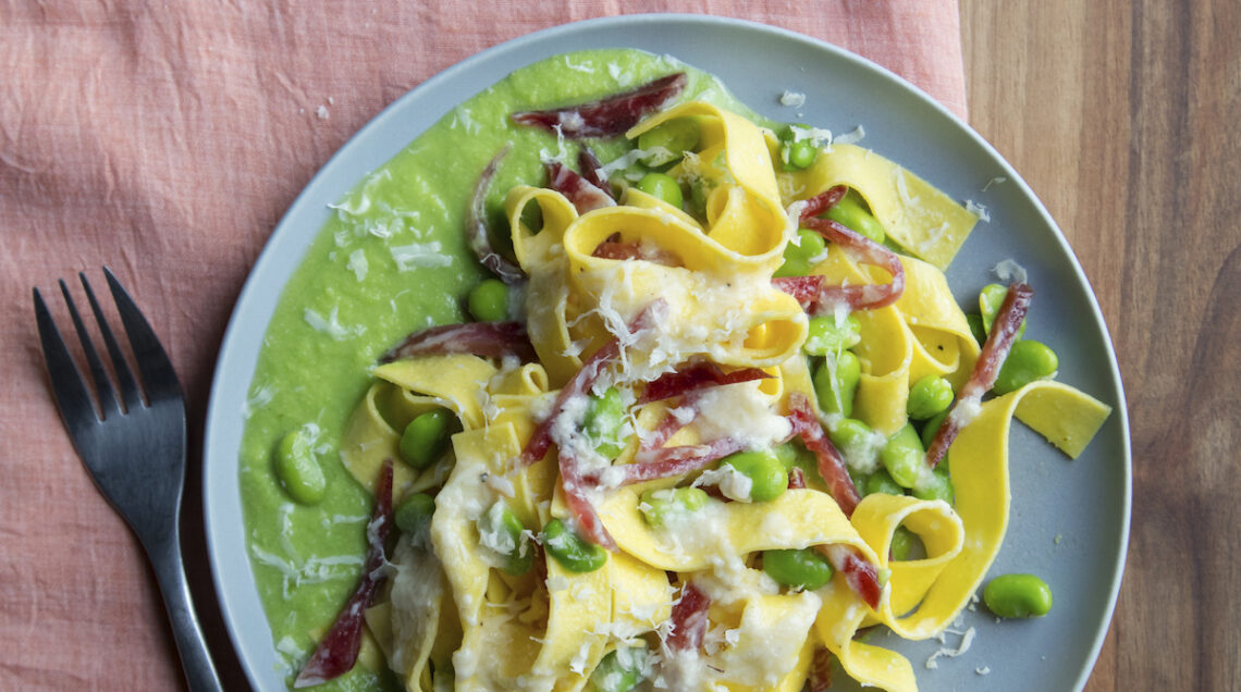 piatto di tagliatelle con crema di fave, fave, salame e pecorino