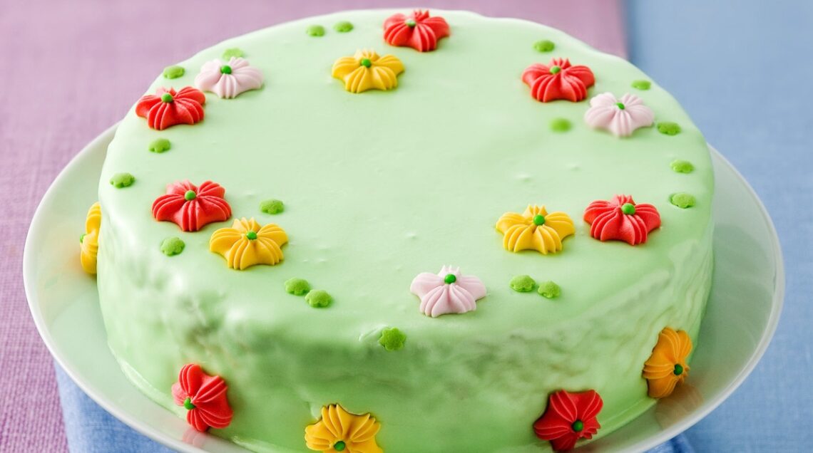 torta con ghiaccia reale verde e fiorellini di zucchero