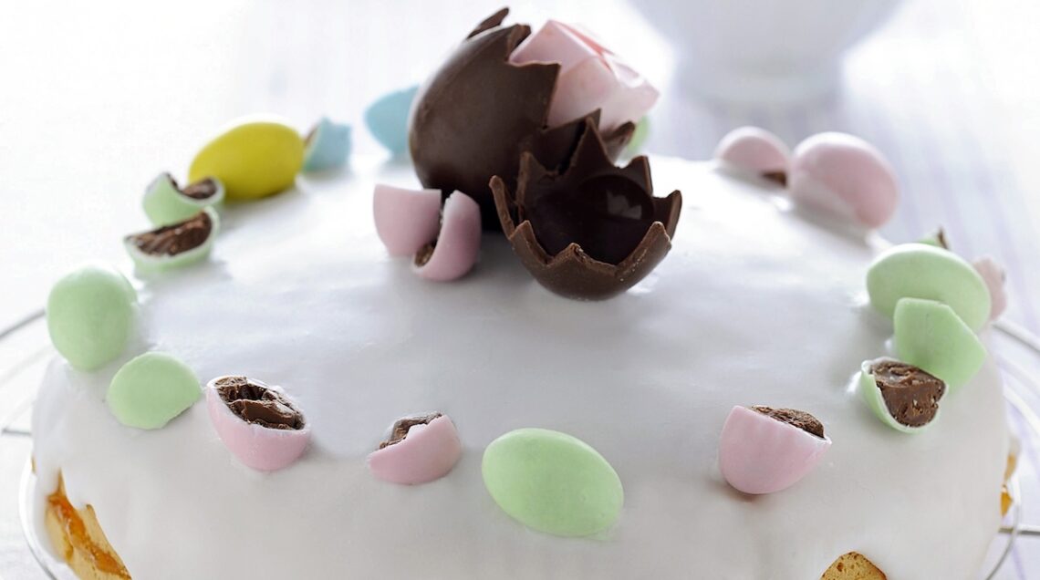 torta con glassa bianca e ovetti di cioccolato e zucchero