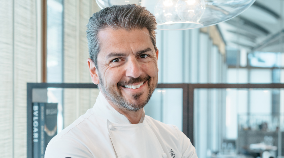 Ritratto dello chef Andrea Berton in divisa bianca da cucina.