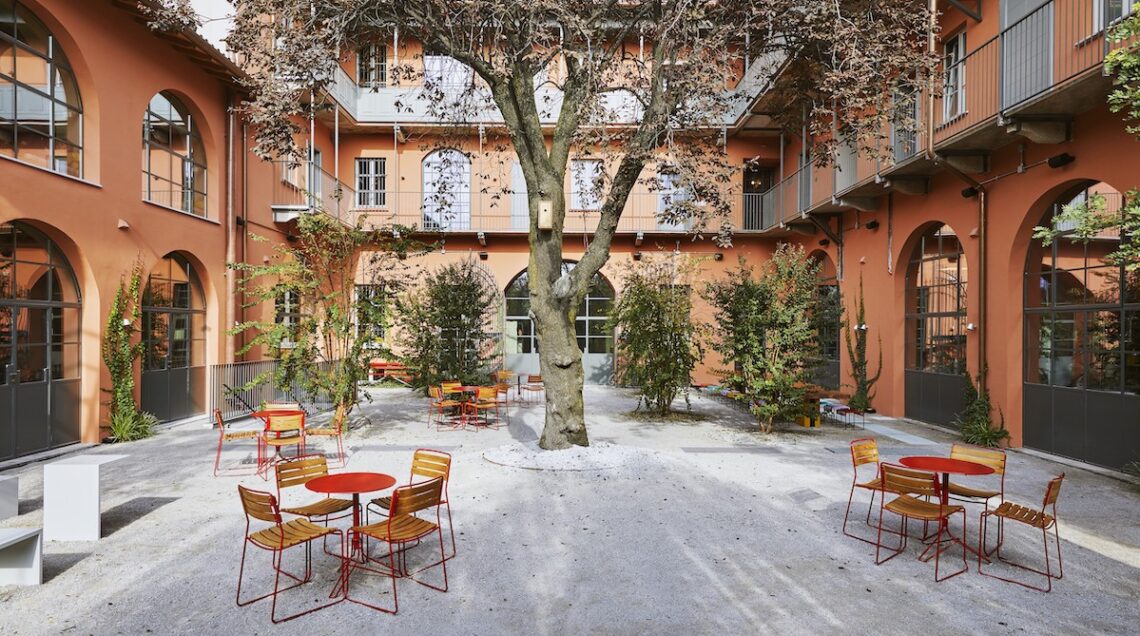 cortile di combo milano con tavolini, sedute e piante