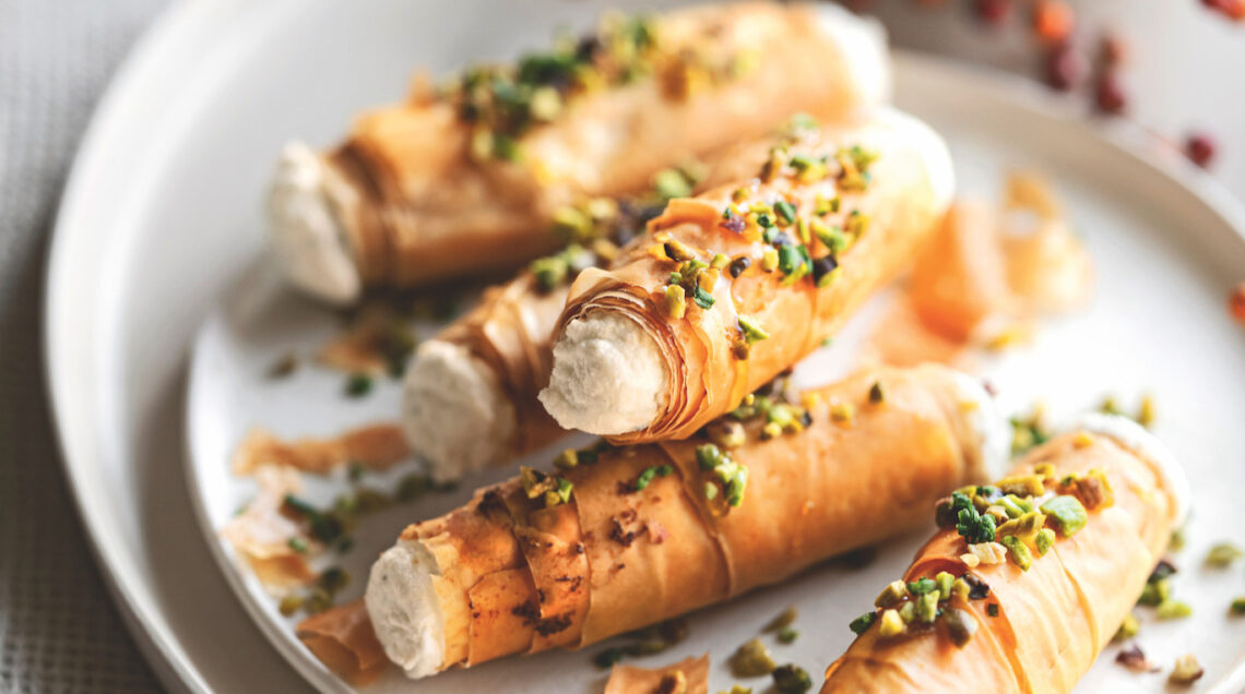 1 confezione di pasta fillo – 40 g di burro – 200 g di ricotta – 2 cucchiai di mascarpone – 80 g di formaggio blu di capra – 1 cucchiaio di miele – 50 g di granella di pistacchi – un mazzetto di erba cipollina – sale – pepe 1 Stendete la pasta fillo sul piano di lavoro e ritagliatela in strisce larghe 5-6 cm e lunghe quanto i fogli di pasta (circa 20-24 cm); spennellatele una alla volta con un po' di burro fuso, unite anche un pizzico di sale e arrotolatele intorno a cannelli di metallo con diametro di 1,5 cm foderati con carta da forno, sovrapponendo 4-5 strisce per ogni cannello e facendo in modo che la pasta non sia troppo stesa, ma crei qualche grinza morbida. 2 Sistemate i cannolini su una placca foderata con carta da forno e cuoceteli nel forno già caldo a 180° finché saranno ben dorati (circa 12-15 minuti). Lasciate intiepidire i cannolini prima di sfilarli delicatamente dai supporti. 3 Lavorate la ricotta con il mascarpone e il formaggio di capra, aggiungendo anche un pizzico di pepe a piacere. Farcite i cannolini con la crema di formaggio usando una sacca da pasticciere, quindi sporcate la superficie con un po' di miele e cospargeteli con la granella di pistacchi e l'erba cipollina tagliuzzata