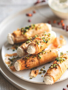 1 confezione di pasta fillo – 40 g di burro – 200 g di ricotta – 2 cucchiai di mascarpone – 80 g di formaggio blu di capra – 1 cucchiaio di miele – 50 g di granella di pistacchi – un mazzetto di erba cipollina – sale – pepe 1 Stendete la pasta fillo sul piano di lavoro e ritagliatela in strisce larghe 5-6 cm e lunghe quanto i fogli di pasta (circa 20-24 cm); spennellatele una alla volta con un po' di burro fuso, unite anche un pizzico di sale e arrotolatele intorno a cannelli di metallo con diametro di 1,5 cm foderati con carta da forno, sovrapponendo 4-5 strisce per ogni cannello e facendo in modo che la pasta non sia troppo stesa, ma crei qualche grinza morbida. 2 Sistemate i cannolini su una placca foderata con carta da forno e cuoceteli nel forno già caldo a 180° finché saranno ben dorati (circa 12-15 minuti). Lasciate intiepidire i cannolini prima di sfilarli delicatamente dai supporti. 3 Lavorate la ricotta con il mascarpone e il formaggio di capra, aggiungendo anche un pizzico di pepe a piacere. Farcite i cannolini con la crema di formaggio usando una sacca da pasticciere, quindi sporcate la superficie con un po' di miele e cospargeteli con la granella di pistacchi e l'erba cipollina tagliuzzata