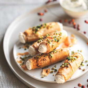 1 confezione di pasta fillo – 40 g di burro – 200 g di ricotta – 2 cucchiai di mascarpone – 80 g di formaggio blu di capra – 1 cucchiaio di miele – 50 g di granella di pistacchi – un mazzetto di erba cipollina – sale – pepe 1 Stendete la pasta fillo sul piano di lavoro e ritagliatela in strisce larghe 5-6 cm e lunghe quanto i fogli di pasta (circa 20-24 cm); spennellatele una alla volta con un po' di burro fuso, unite anche un pizzico di sale e arrotolatele intorno a cannelli di metallo con diametro di 1,5 cm foderati con carta da forno, sovrapponendo 4-5 strisce per ogni cannello e facendo in modo che la pasta non sia troppo stesa, ma crei qualche grinza morbida. 2 Sistemate i cannolini su una placca foderata con carta da forno e cuoceteli nel forno già caldo a 180° finché saranno ben dorati (circa 12-15 minuti). Lasciate intiepidire i cannolini prima di sfilarli delicatamente dai supporti. 3 Lavorate la ricotta con il mascarpone e il formaggio di capra, aggiungendo anche un pizzico di pepe a piacere. Farcite i cannolini con la crema di formaggio usando una sacca da pasticciere, quindi sporcate la superficie con un po' di miele e cospargeteli con la granella di pistacchi e l'erba cipollina tagliuzzata